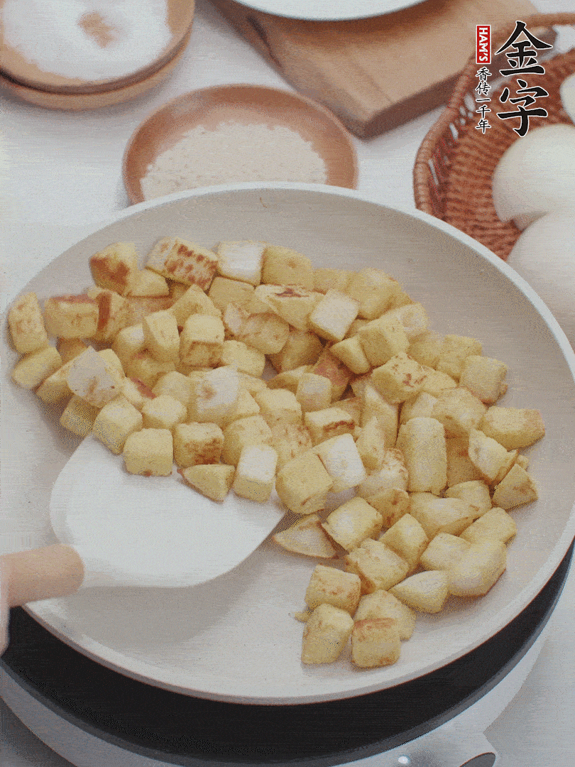 起鍋熱油，倒入饅頭丁，小火煎至蛋液凝固定型再翻面，饅頭丁部煎至金黃時盛起待用。