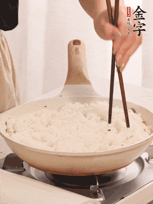 把瀝干水分的米飯均勻鋪在上面，筷子戳幾個(gè)洞，以便透氣，轉(zhuǎn)小火蓋上蓋子燜至水分收干，大概10分鐘。